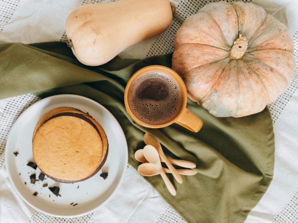 Tasty pancakes served with a hot coffee and seasonal squash, perfect for a cozy brunch.