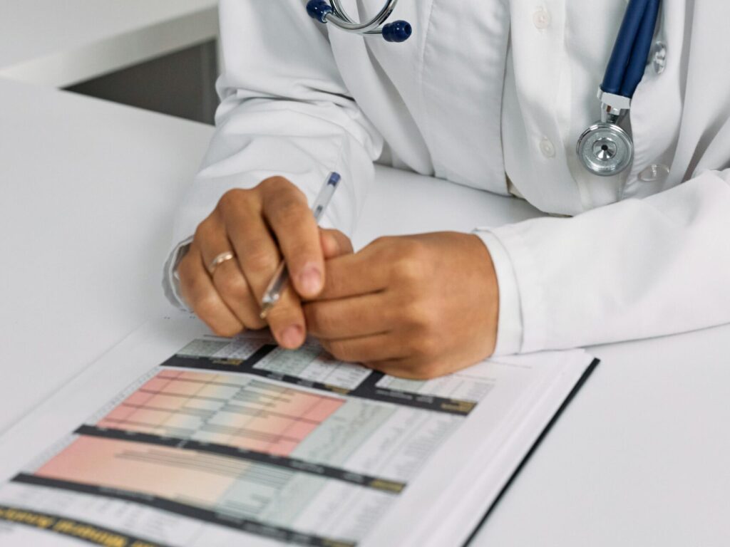 Professional African American female doctor reviewing documents in a clinical setting.