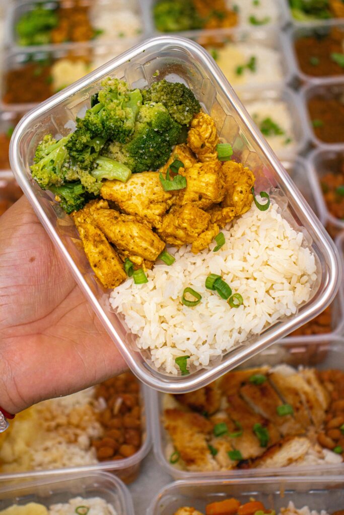 Meal prep featuring chicken, broccoli, and rice in a container, perfect for healthy eating on-the-go.